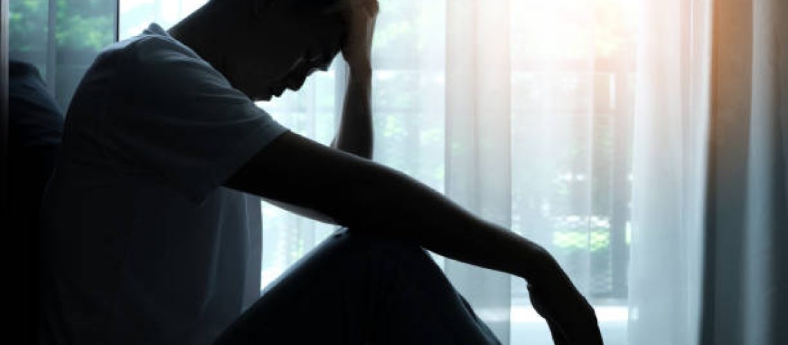 The man sitting in the corner of the room has emotional and mental problems He has depression and stress from society and work. medical concept.